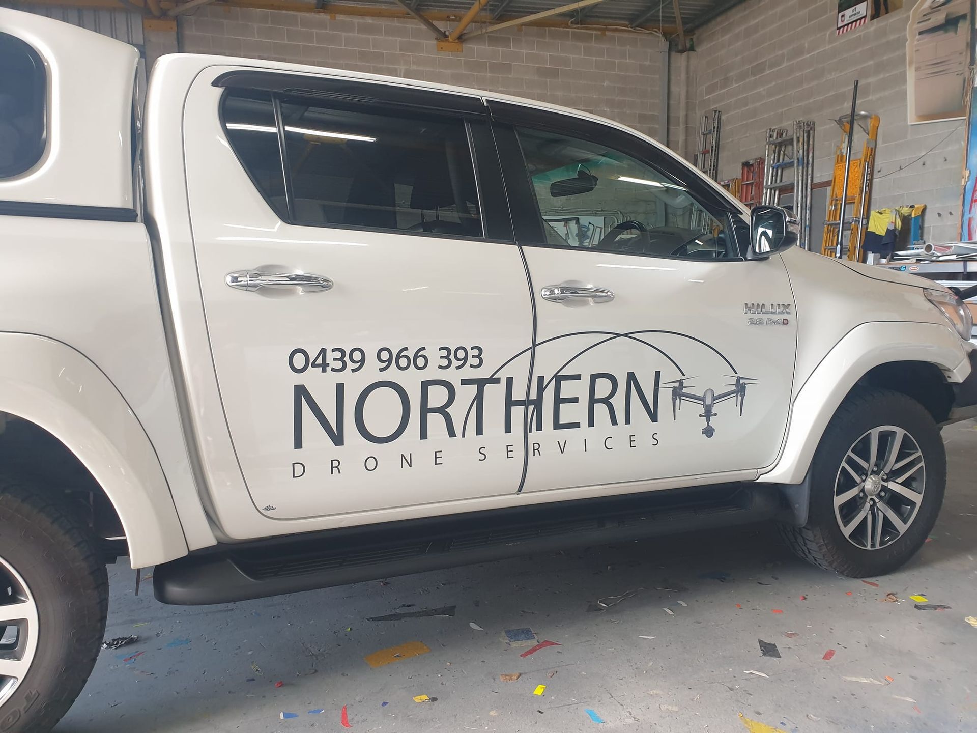A white truck with the word northern on the side is parked in a garage.