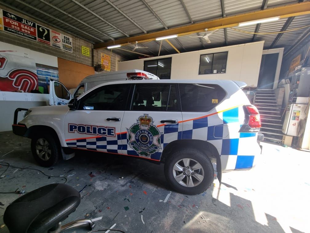 A white and blue police car is parked in a garage.