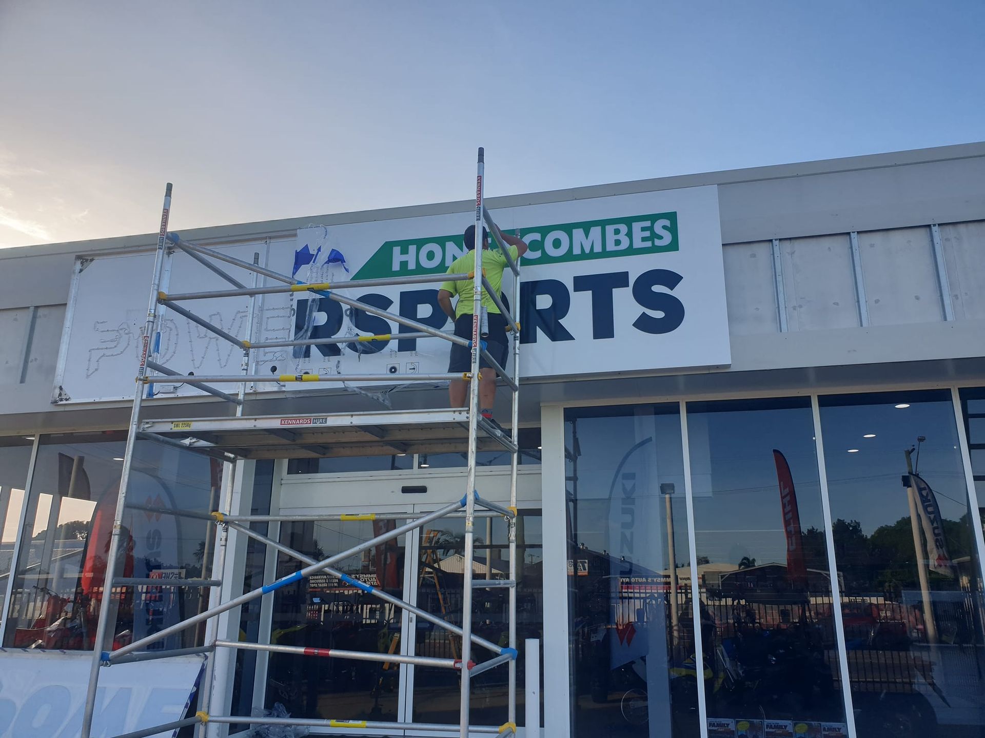 A sign is being installed on the side of a building.