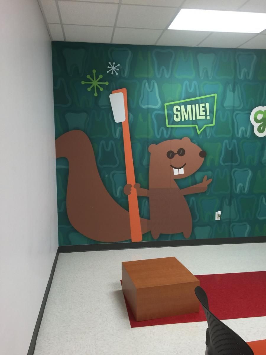 A mural in a dental office depicts a beaver holding a giant toothbrush. 
