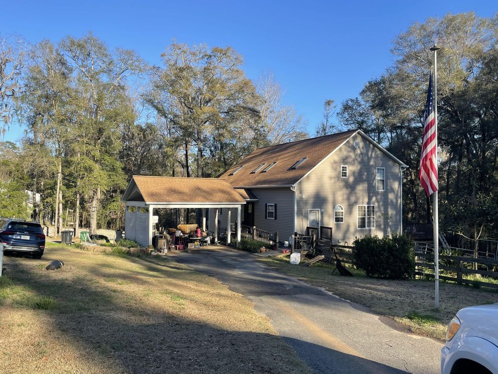 A house with a porch and an american flag in front of it.