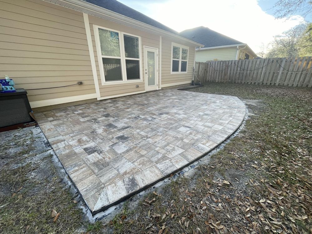 There is a patio in the backyard of a house.