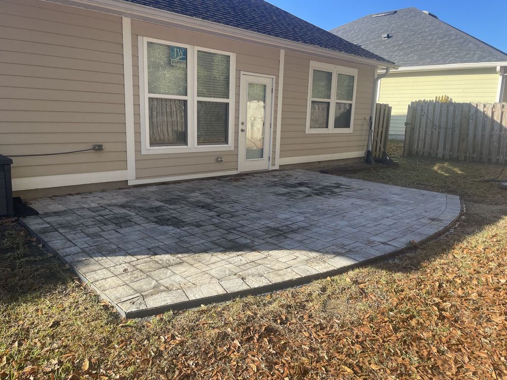 A house with a patio in front of it and a fence.