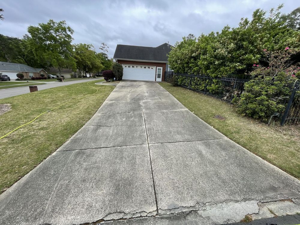 A concrete driveway leading to a house with a garage.