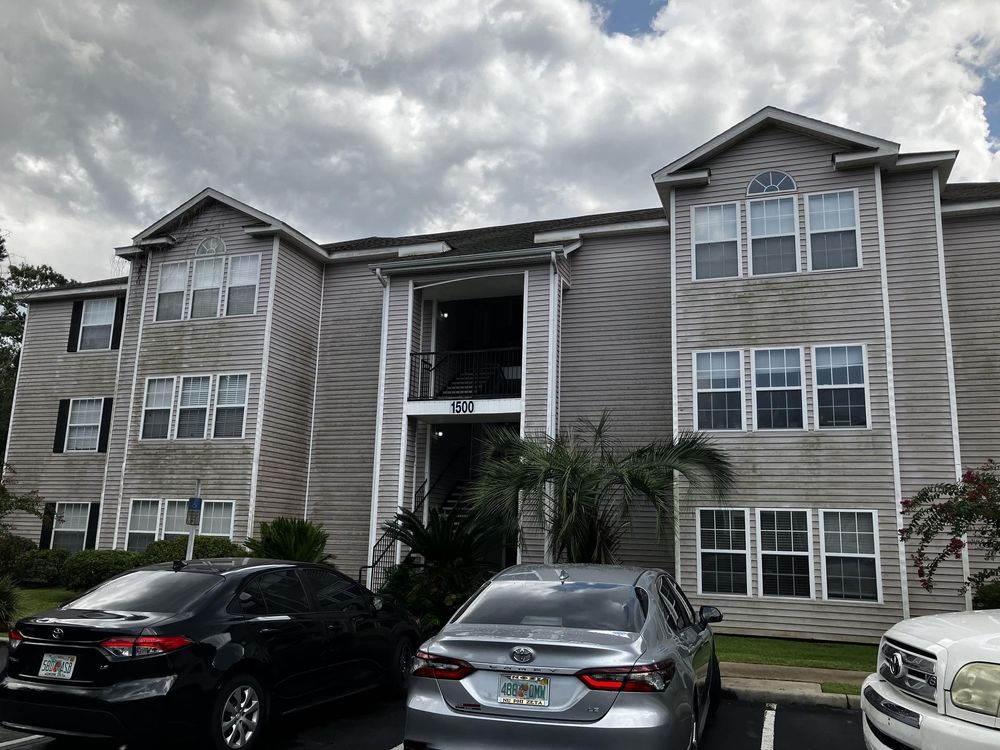 A large apartment building with cars parked in front of it