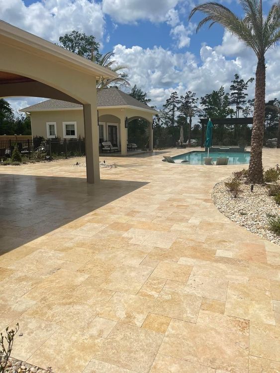 A patio with a pool and a house in the background