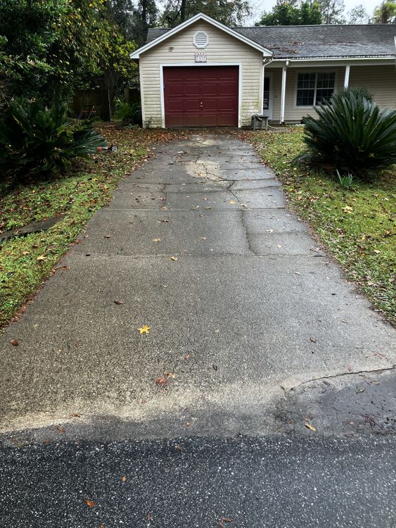 A driveway leading to a house with a red garage door