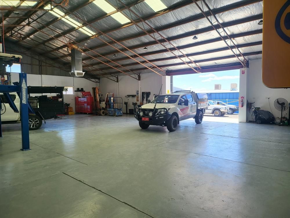A White Truck is Parked in a Garage With a Large Door Open — Sam’s Auto Electrical In Golden Square, VIC