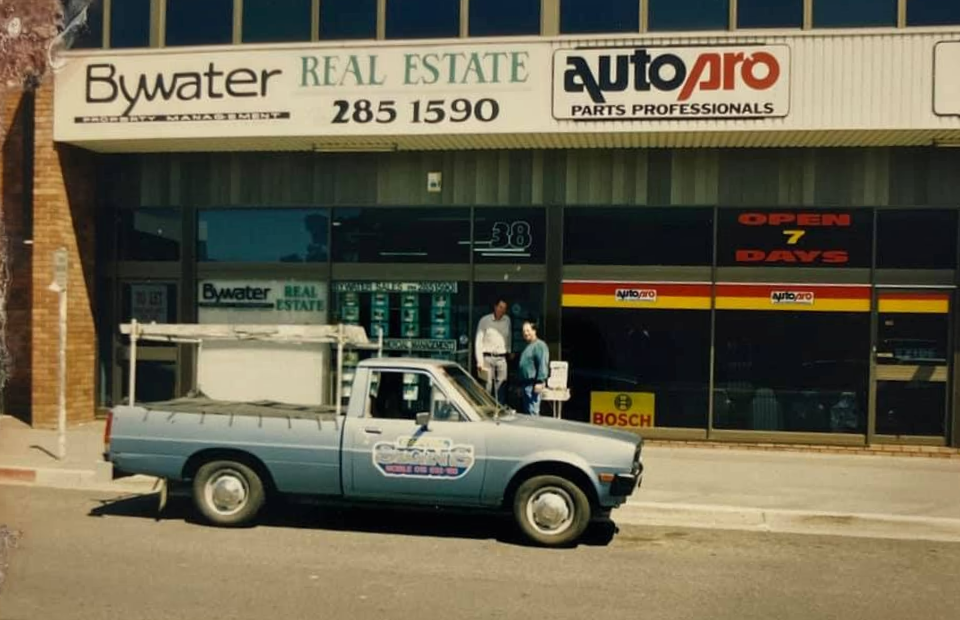A Blue Truck Is Parked In Front Of A Building That Says Bywater Real Estate — Capital Signs in Fyshwick, ACT
