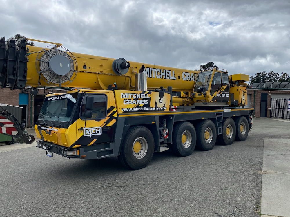 A Large Yellow Crane Truck Is Parked In A Parking Lot — Capital Signs in Fyshwick, ACT