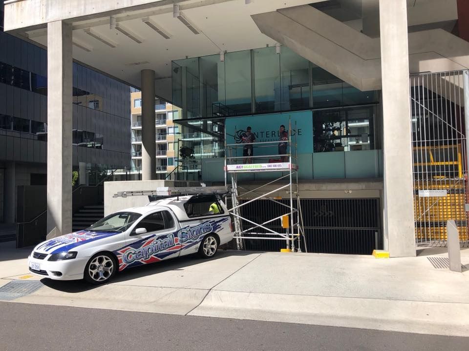 A White Truck Is Parked In Front Of A Building — Capital Signs in Cooma, NSW