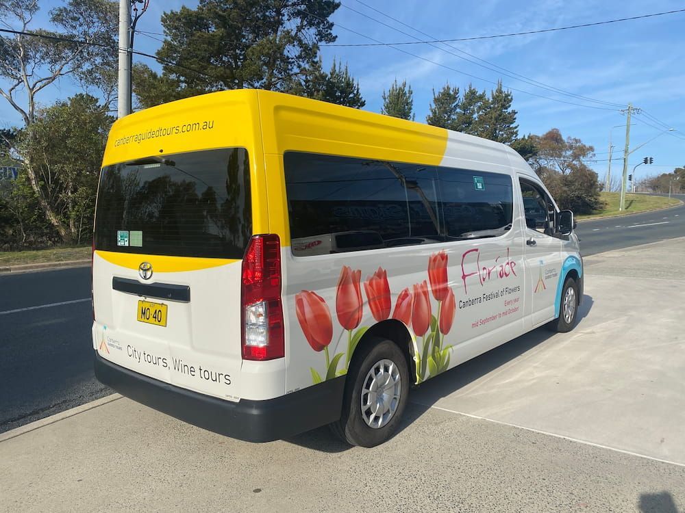 A White And Yellow Van With Flowers On The Side Is Parked — Capital Signs in Canberra, ACT