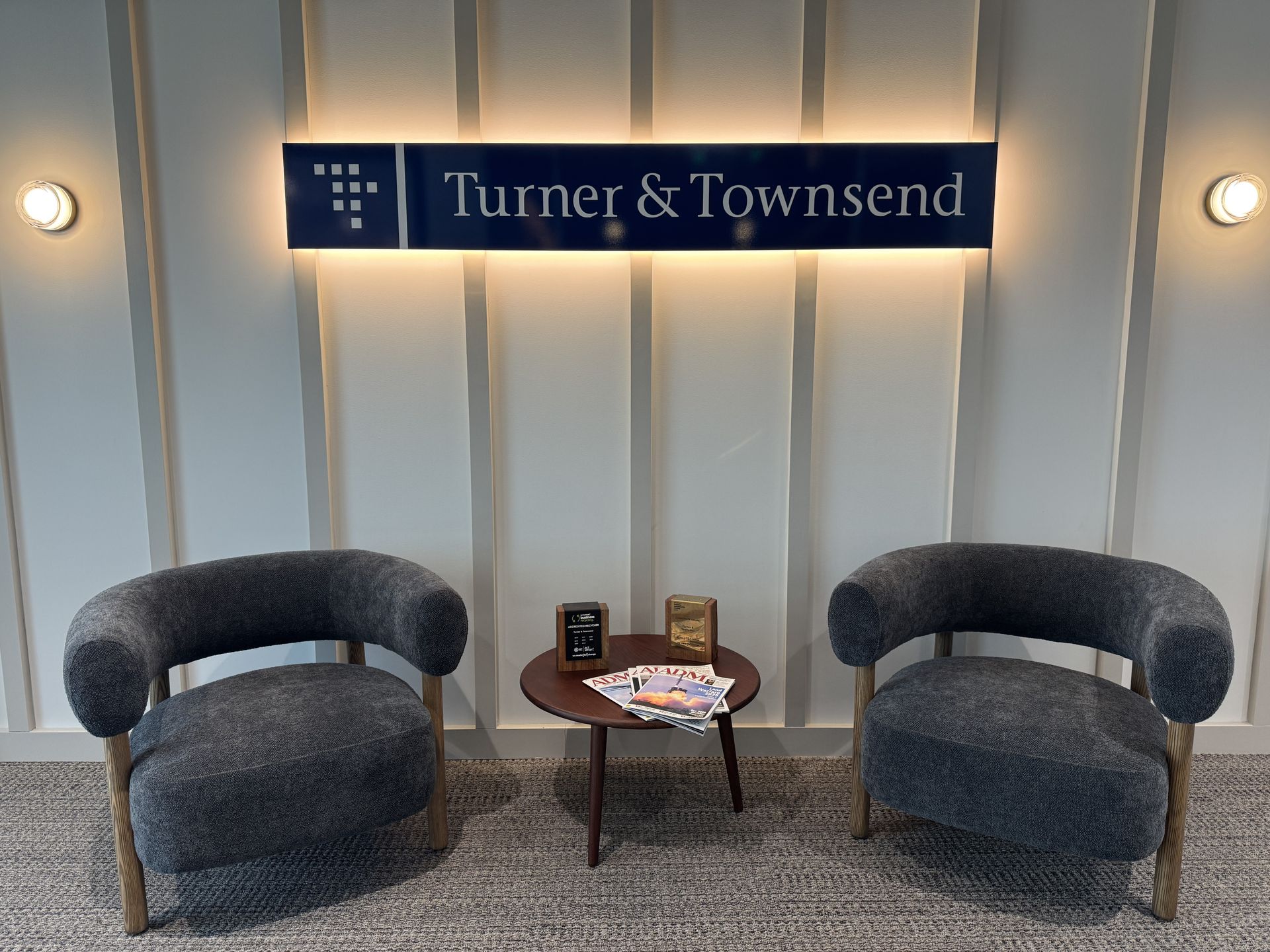Reception area with two gray chairs, small table, and Turner & Townsend sign — Capital Signs in Fyshwick, ACT