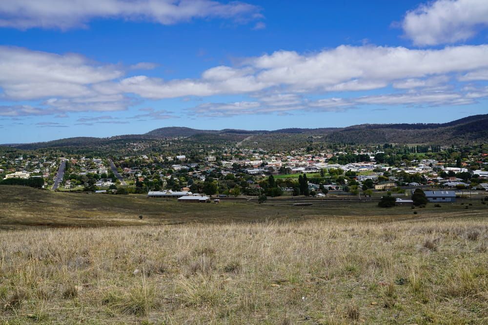 A View Of A City From A Hill With A Blue Sky And Clouds — Capital Signs in Cooma, NSW
