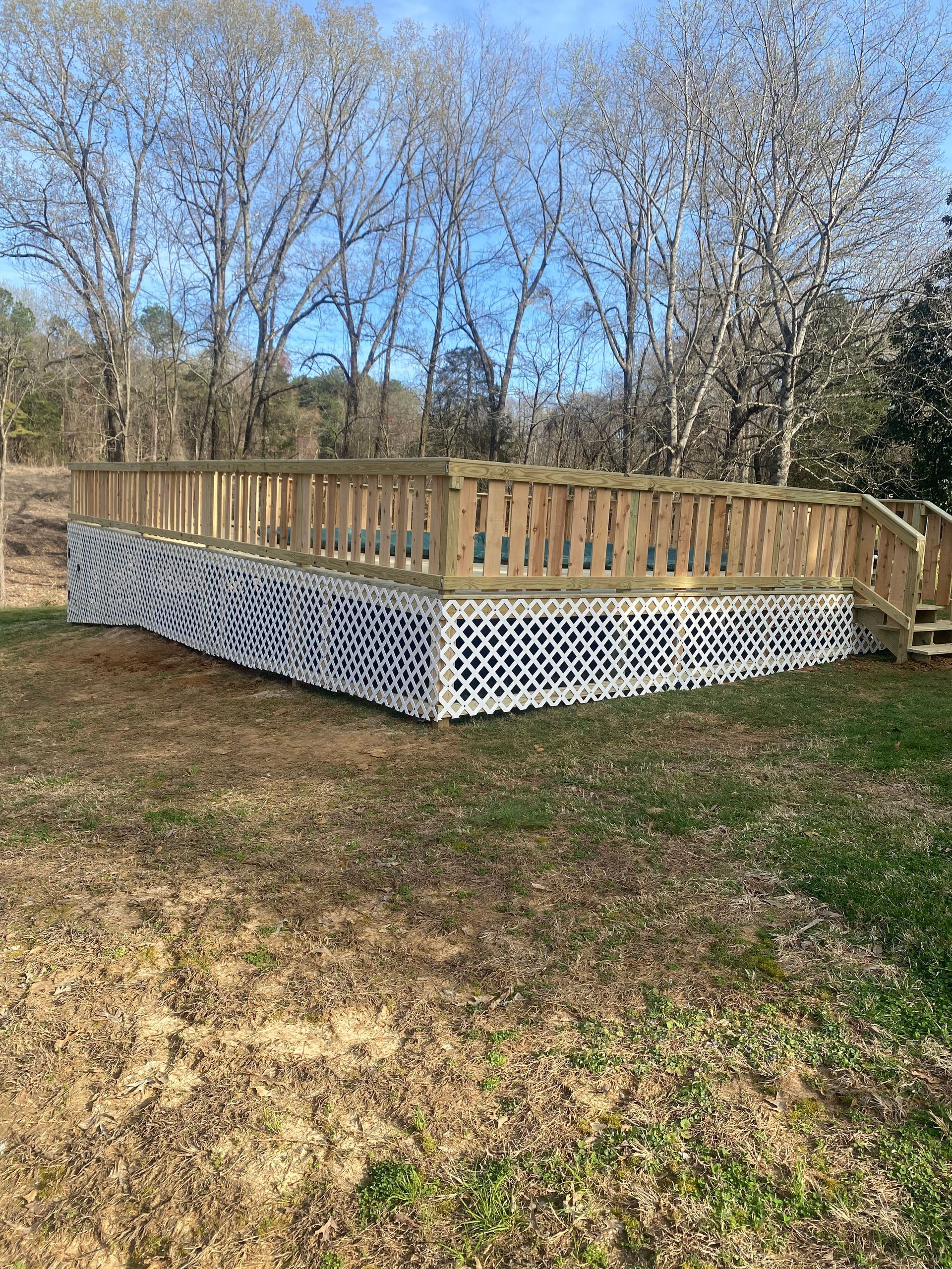 Wooden deck with latticework skirting in a grassy backyard.