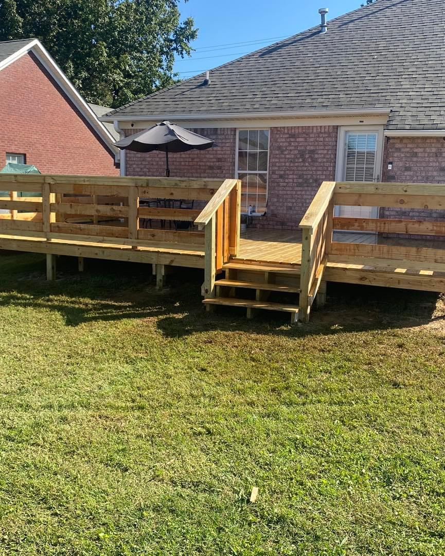 Wooden deck with stairs in backyard of brick house.