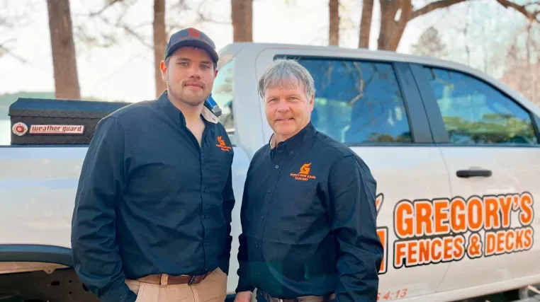 Two men standing beside a white truck with