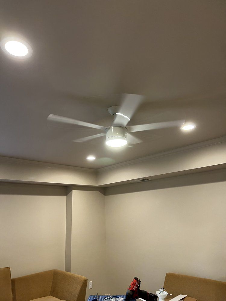 Ceiling fan with lights in a room with tan walls and trim.