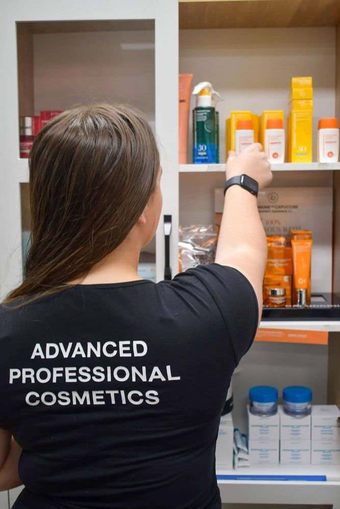 Woman standing in front of a shelf full of cosmetics — Shepparton Skin & Body