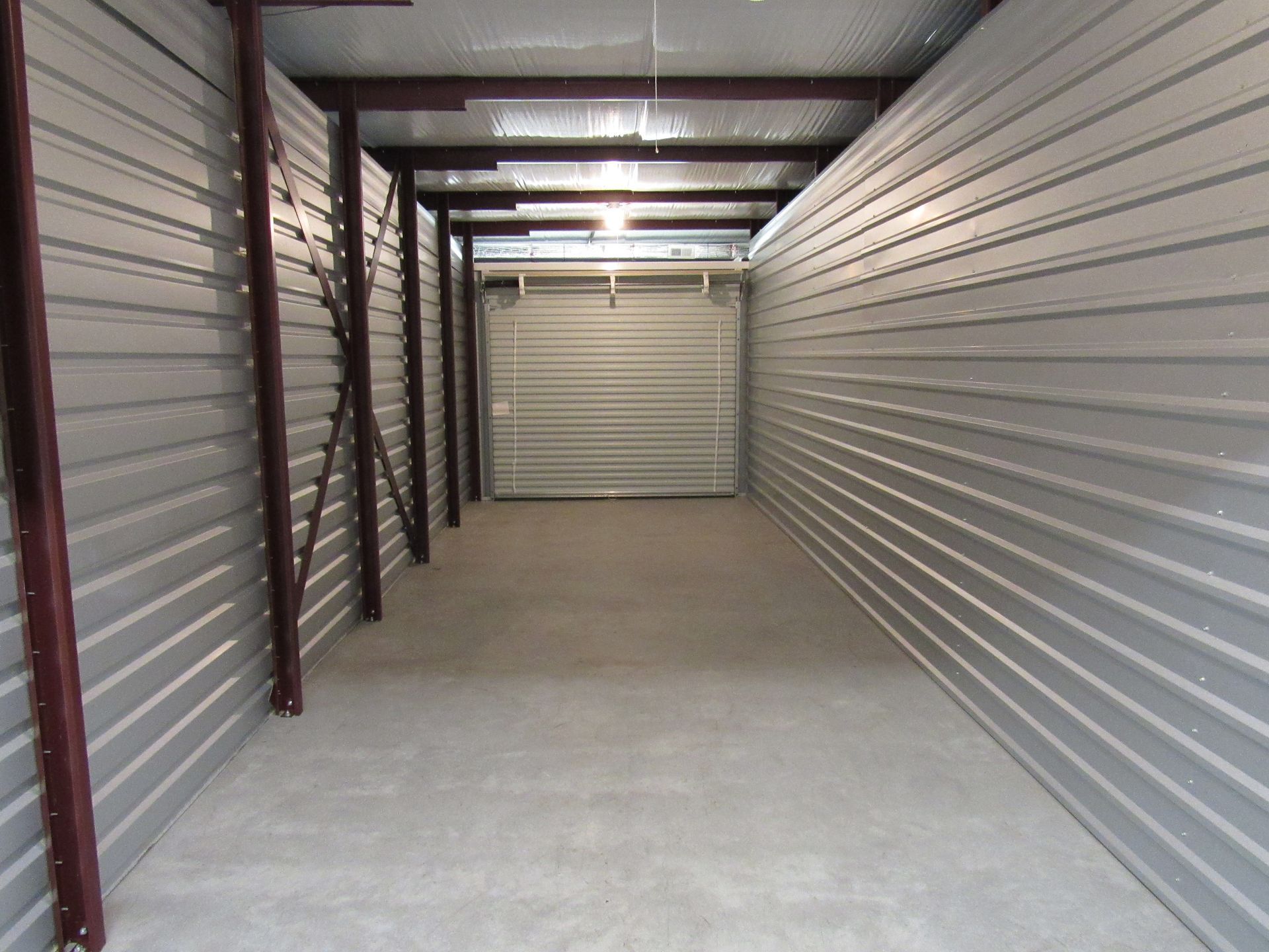 Empty, metal storage unit with a corrugated steel door.