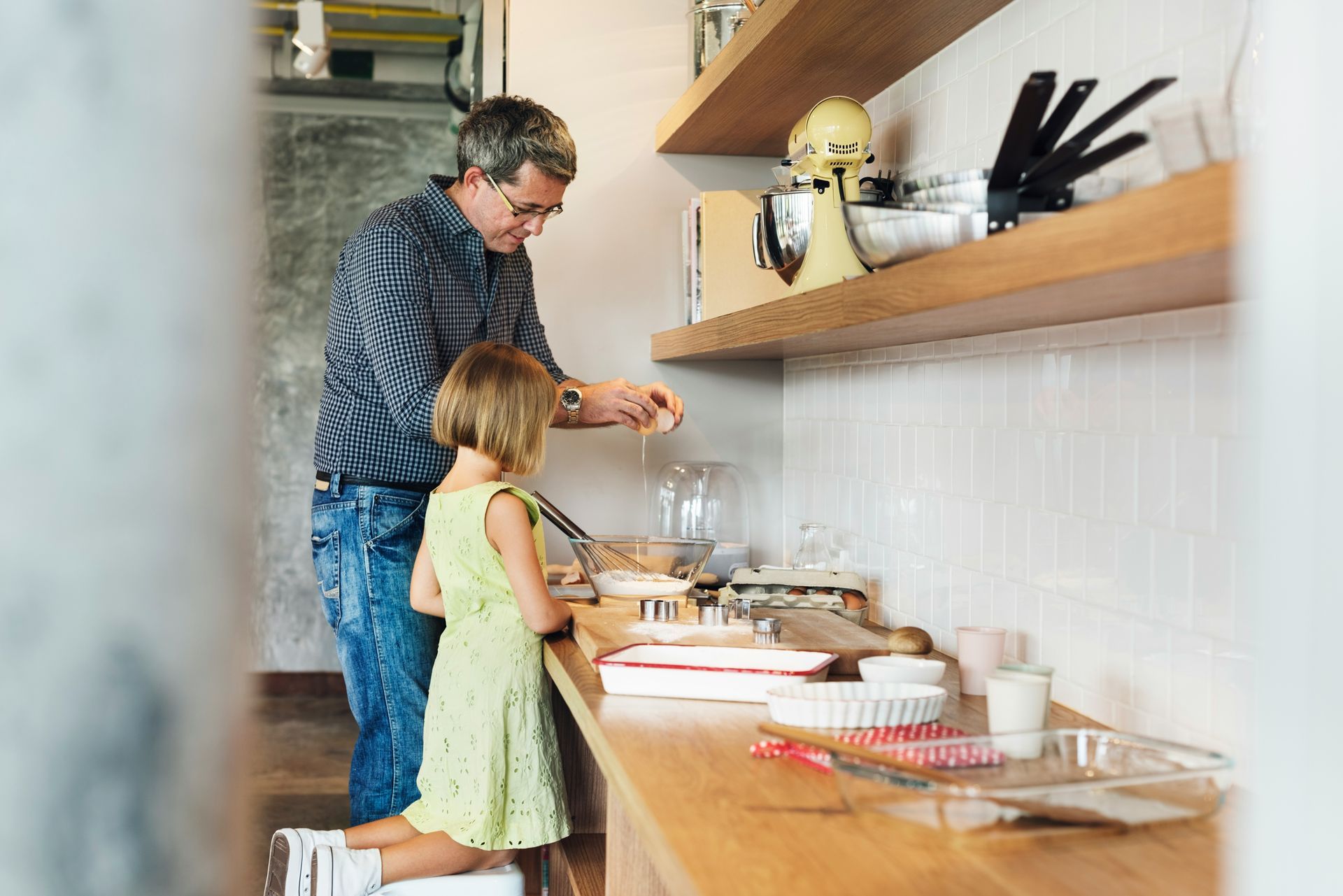 Man and child baking together in a kitchen.