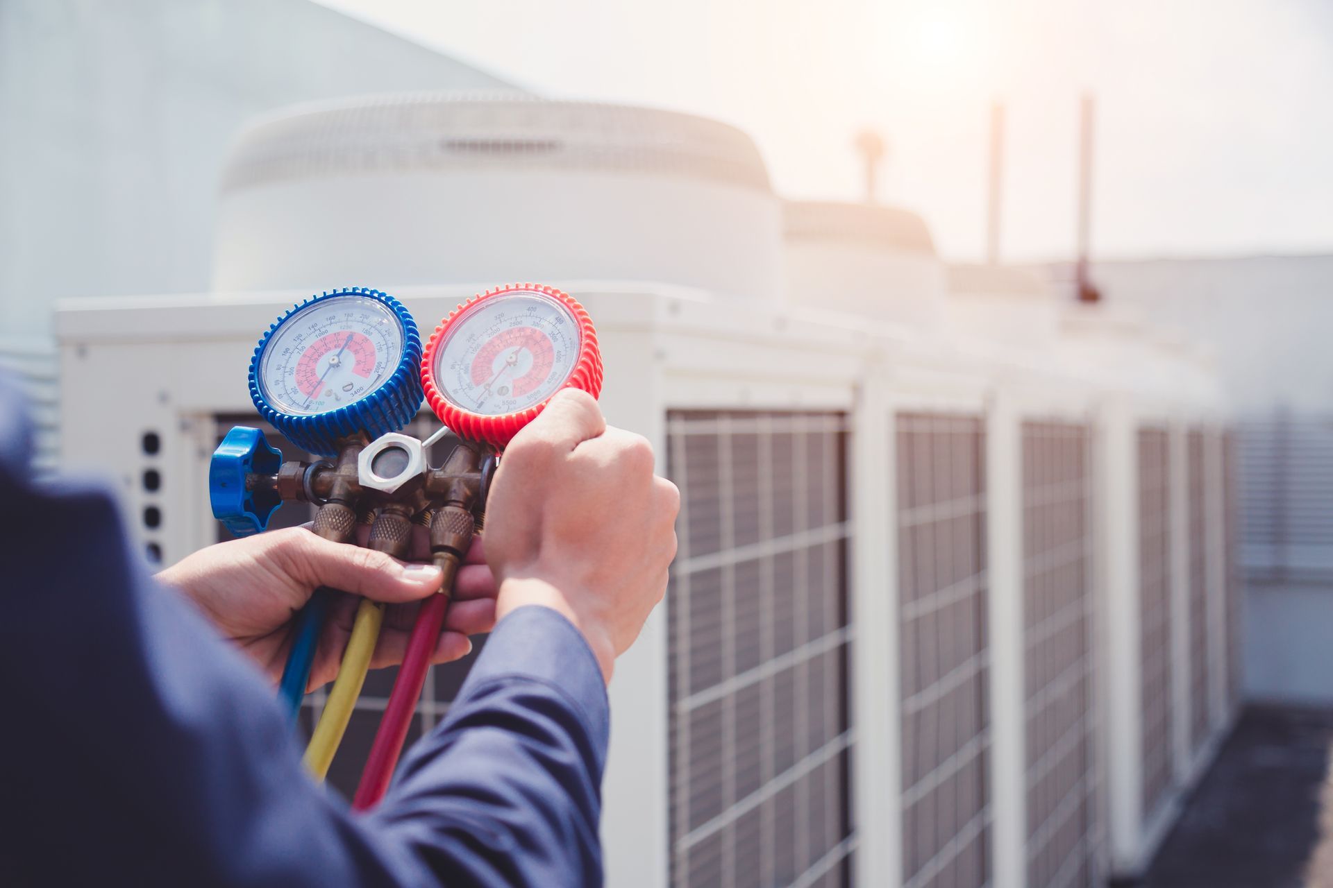 A man is working on an air conditioner outside of a building.