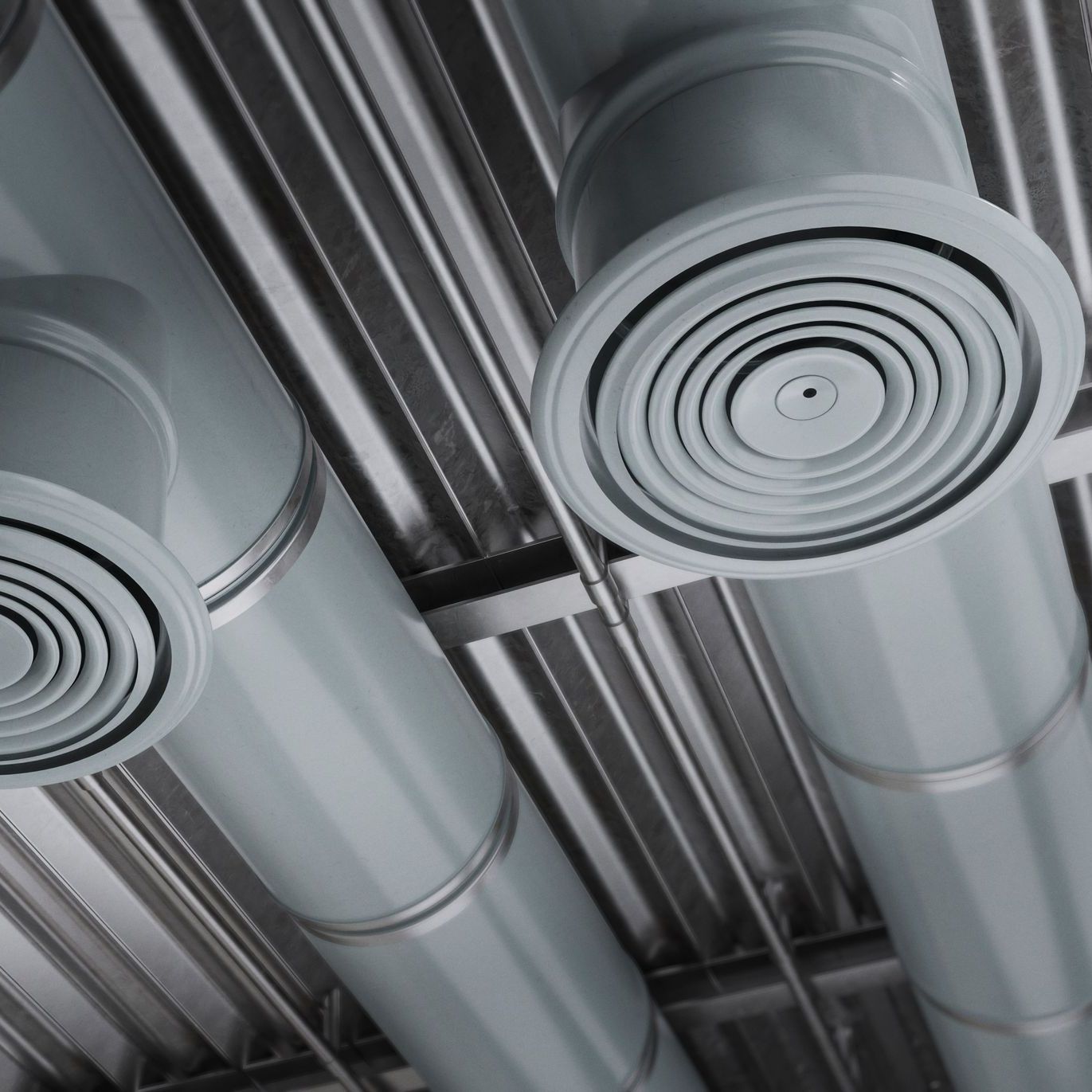 A bunch of ducts are hanging from the ceiling of a building.