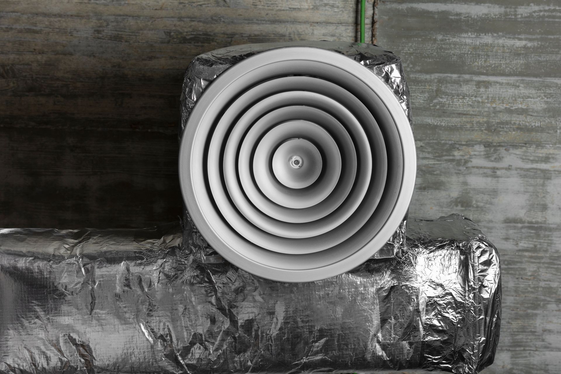 A black and white photo of a circular air vent