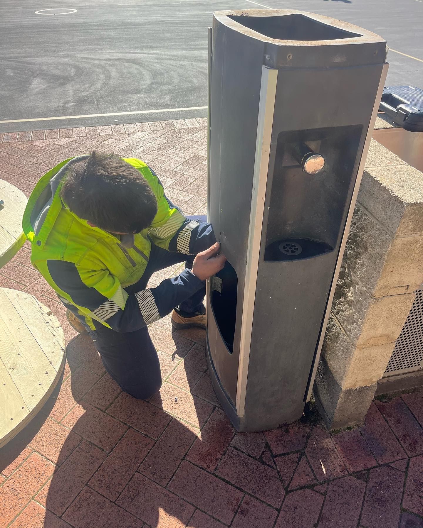 Person in Vest Repairing a Water Fountain Outside — J & H Plumbing and Gas in Holt, ACT
