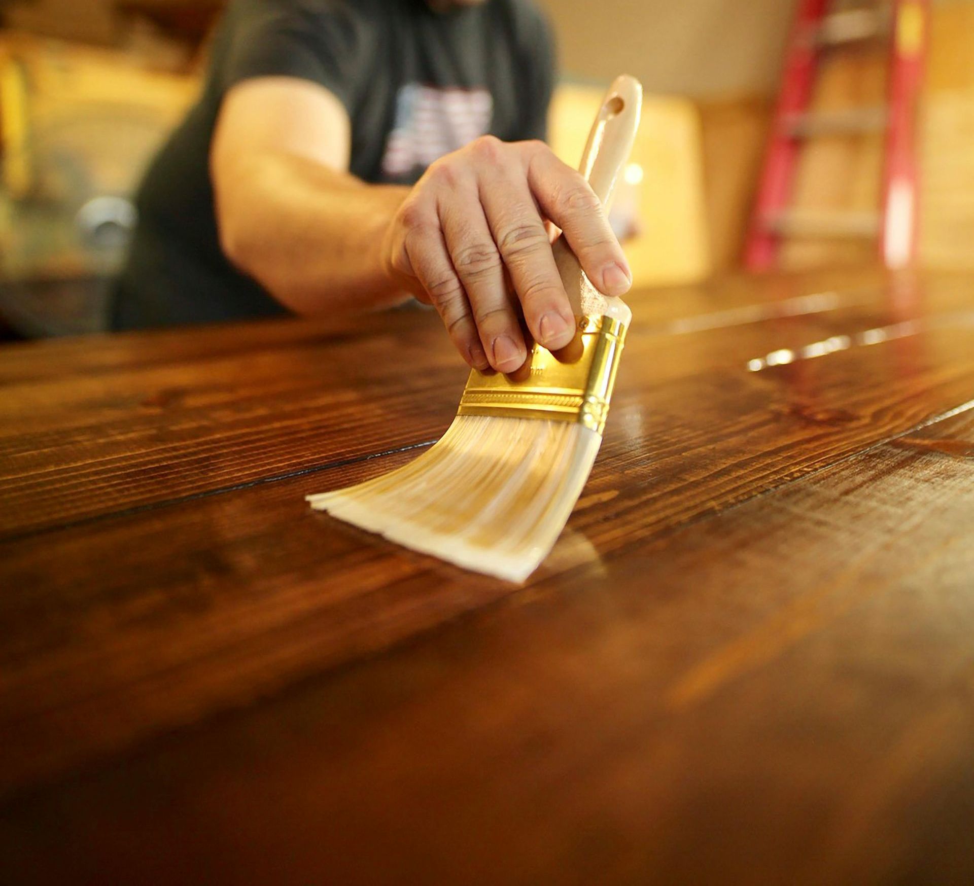 A kitchen under construction with white cabinets and a circular saw on the floor.