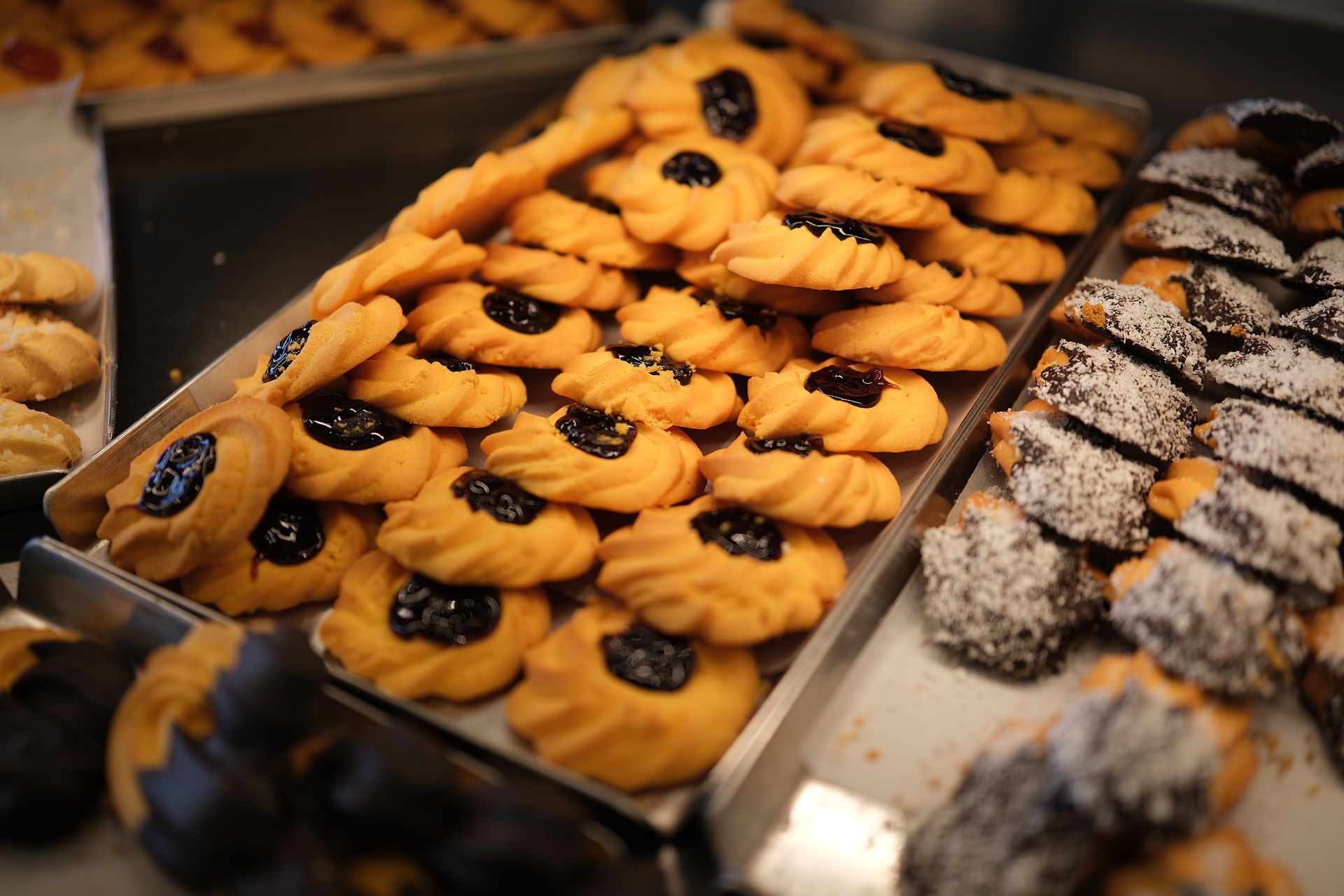 Biscotti esposti in una vetrina da pasticceria; diverse varietà, tra cui quelli ripieni di marmellata 