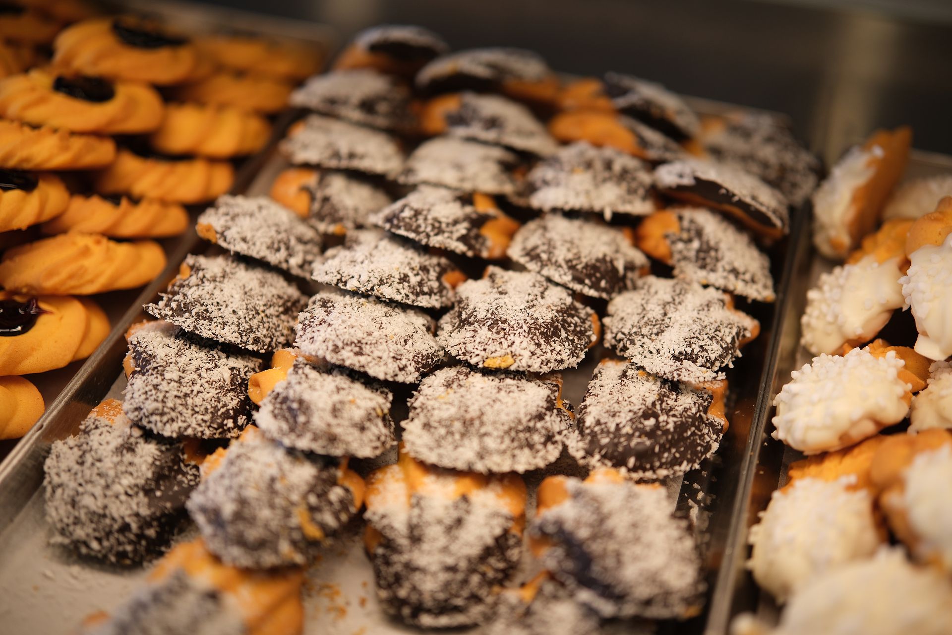 Biscotti su un vassoio di metallo, tra cui quelli ricoperti di cioccolato e quelli con la copertura di cocco