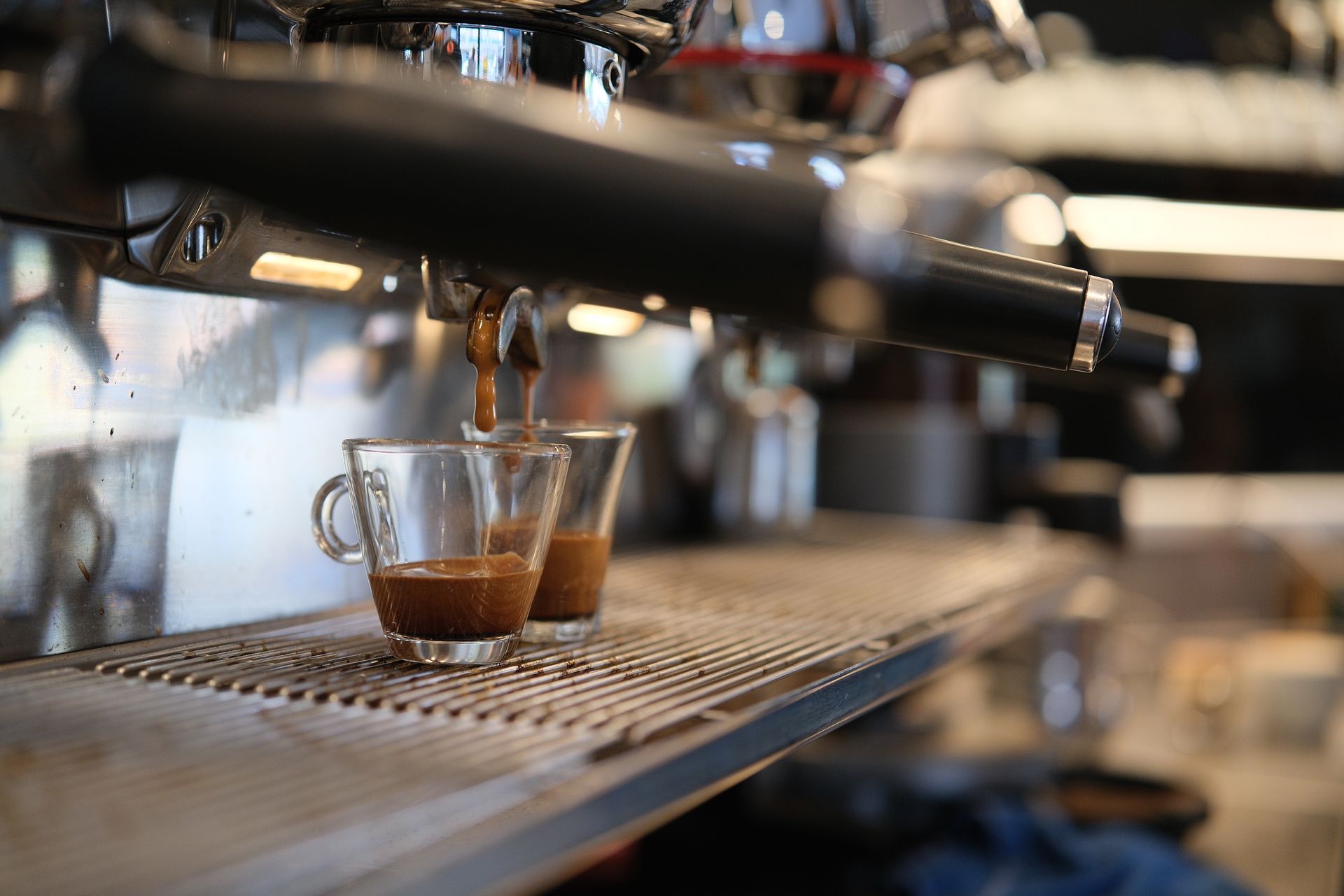 Macchina per caffè espresso che eroga il caffè in due tazze di vetro.