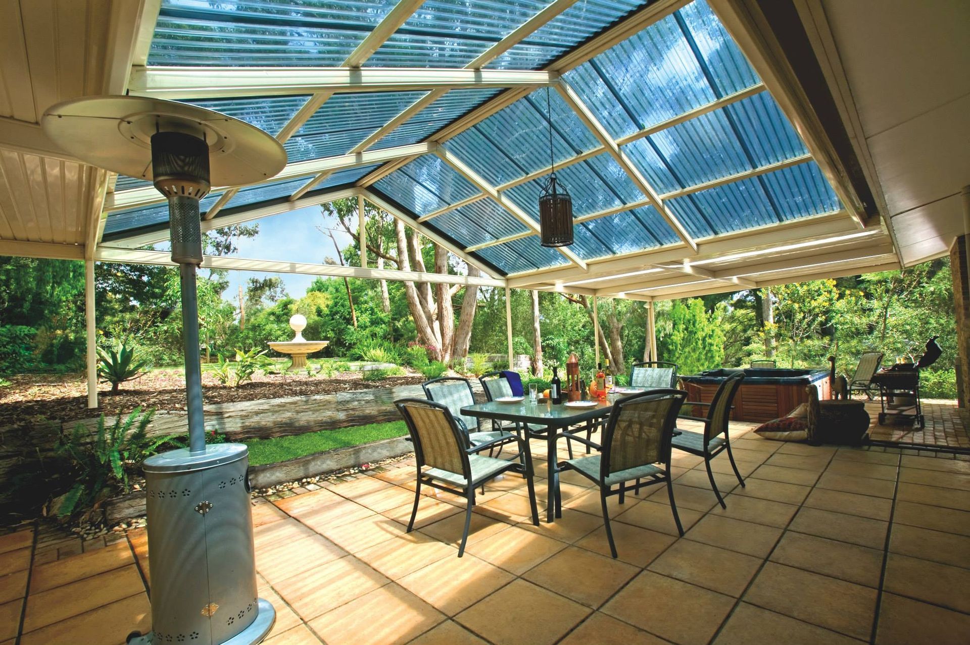 A patio with a table and chairs under a clear roof.