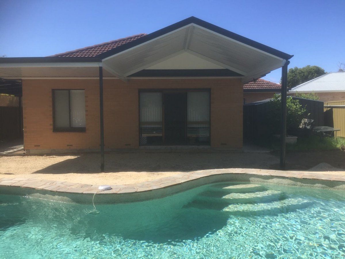 A house with a swimming pool and shades.
