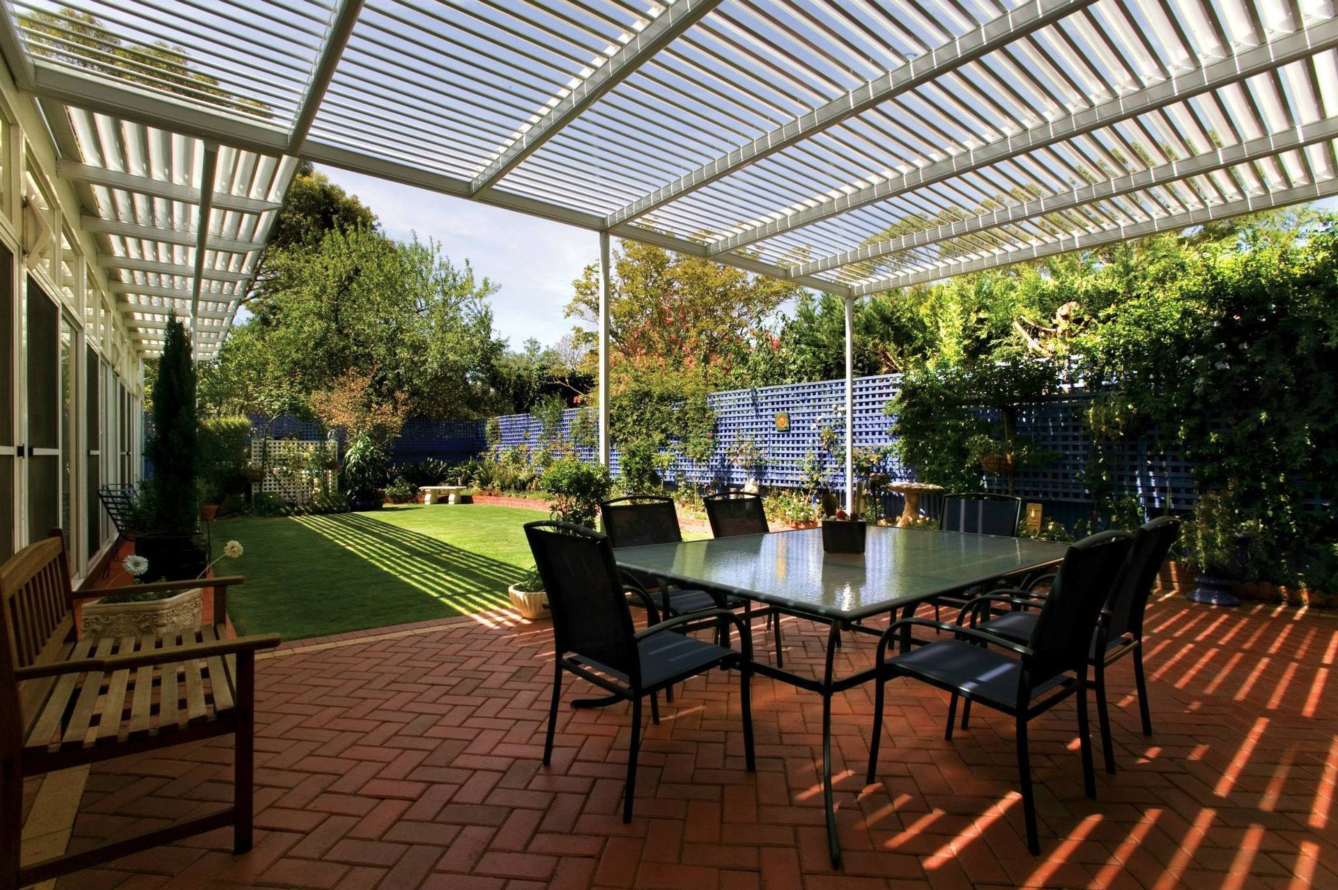A patio with a table and chairs under a pergola.
