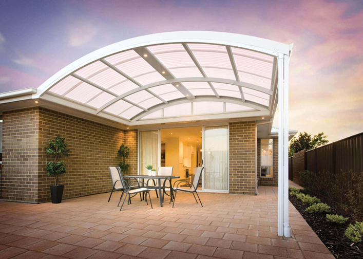 A patio with a table and chairs under a curved canopy.