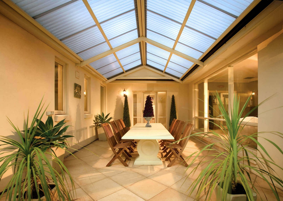 A patio with a table and chairs under a skylight