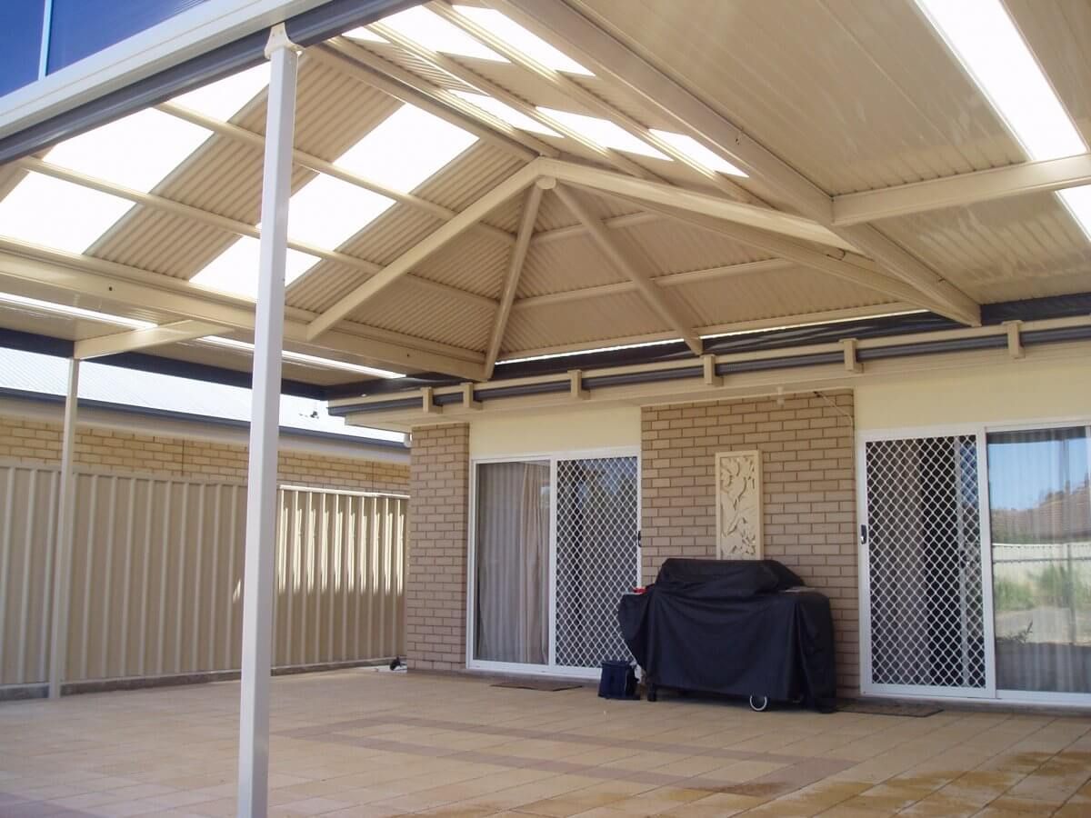 A patio with a grill under a covered roof