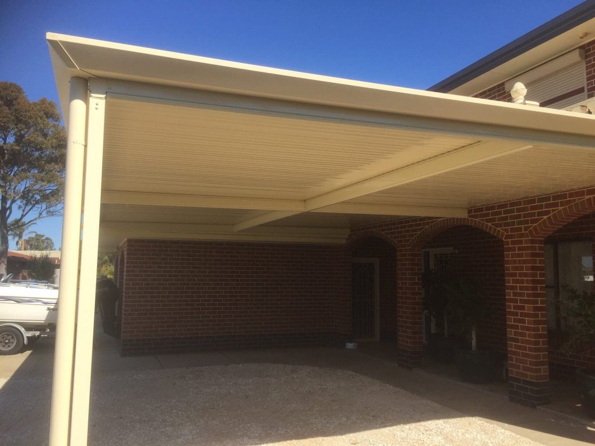 A brick house with a white awning over the driveway.