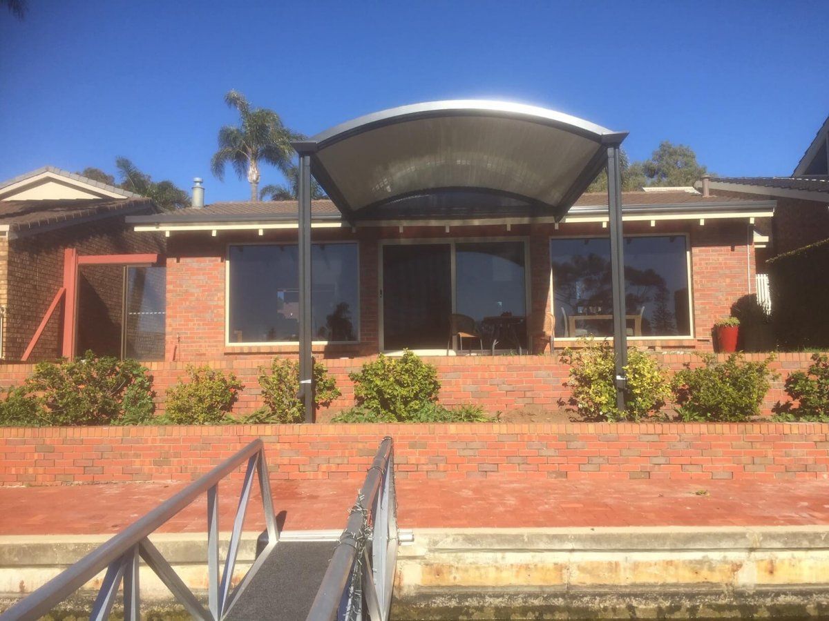 A brick house with a dock in front of it.