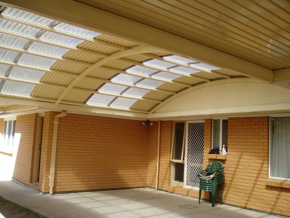 A brick house with a covered porch and a green chair