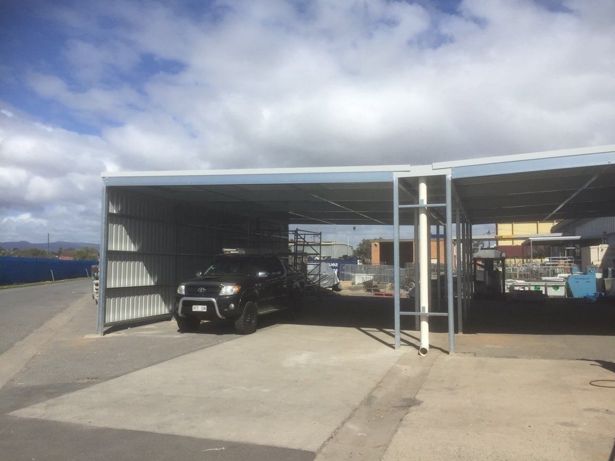 A car is parked under a canopy in a parking lot