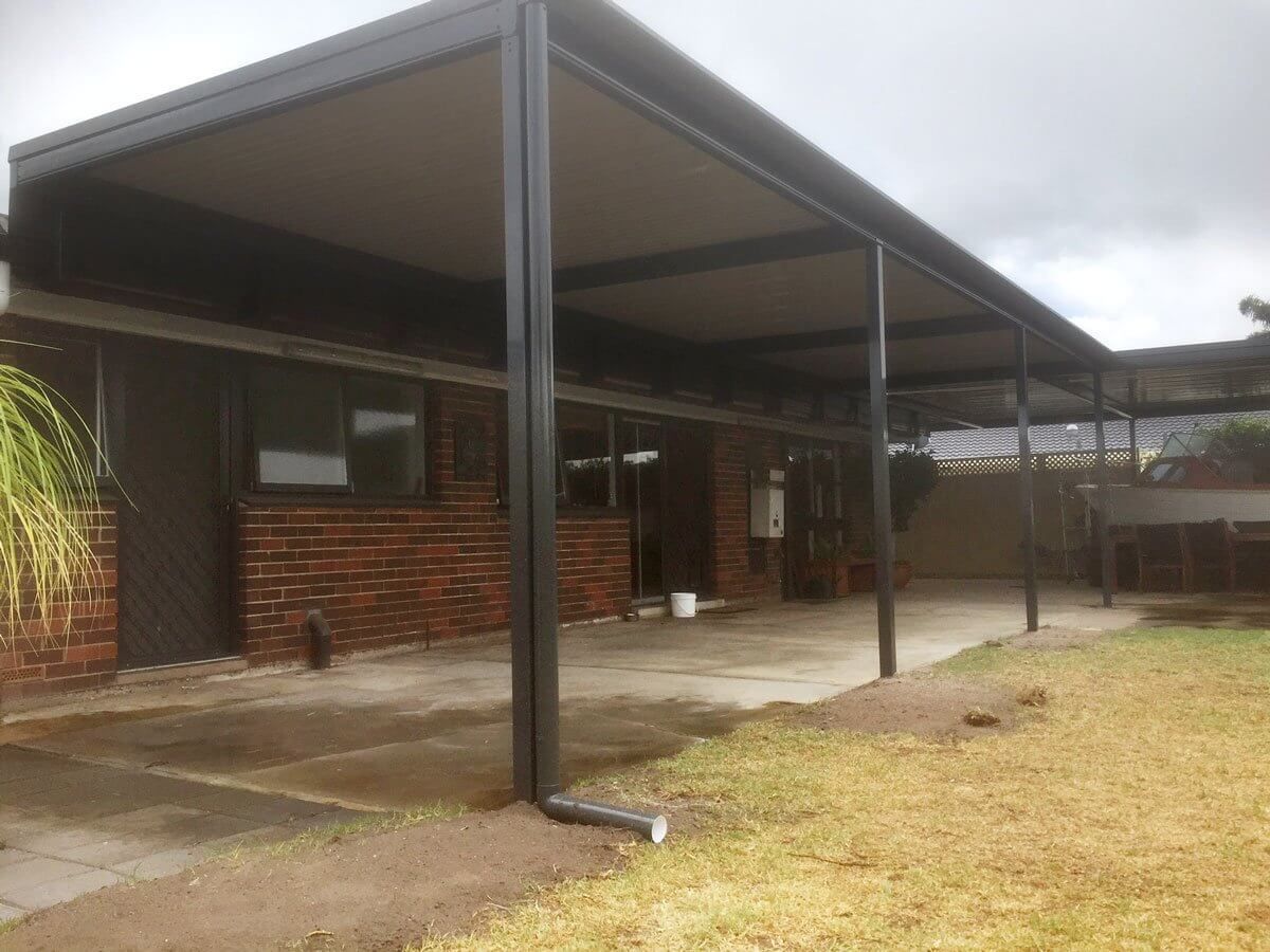A house with a covered patio in front of it.