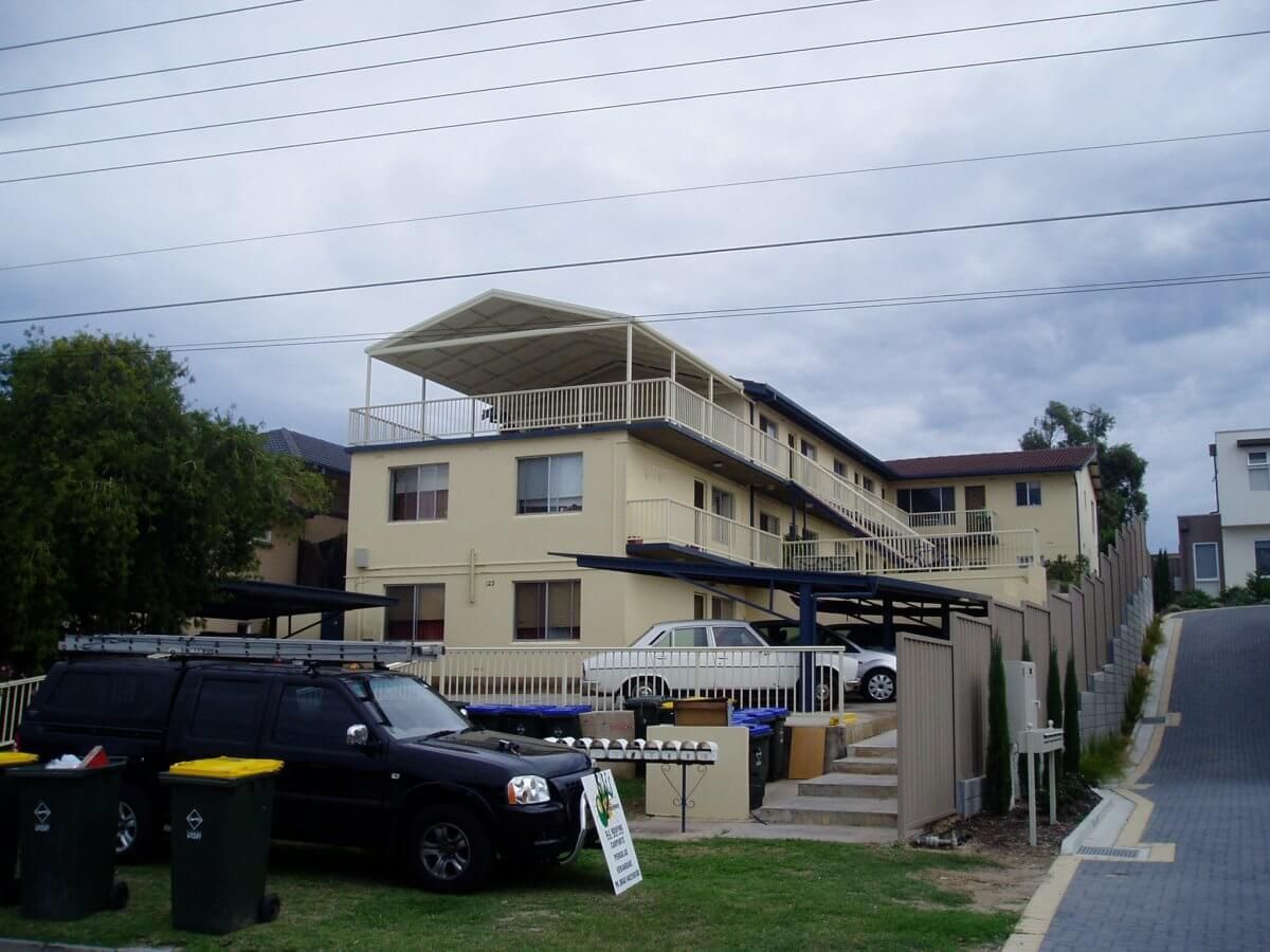A black suv is parked in front of a large house