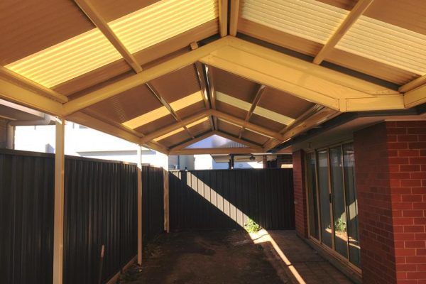 A house with a yellow roof and a black fence