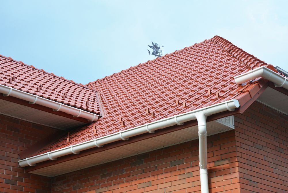 A Brick House With A Red Tiled Roof And White Gutters — D L Contor Plumbing & Drainage In Mackay, QLD