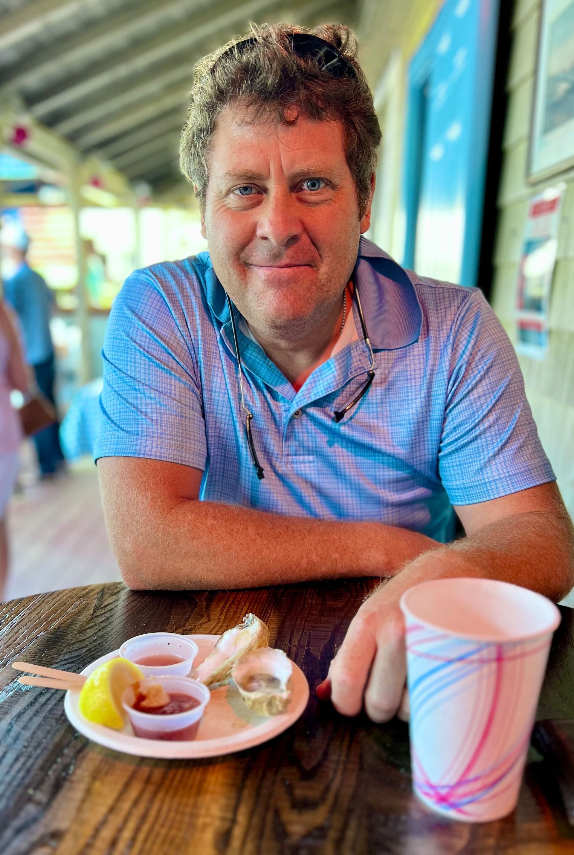 A man is sitting at a table with a plate of food and a cup of coffee.
