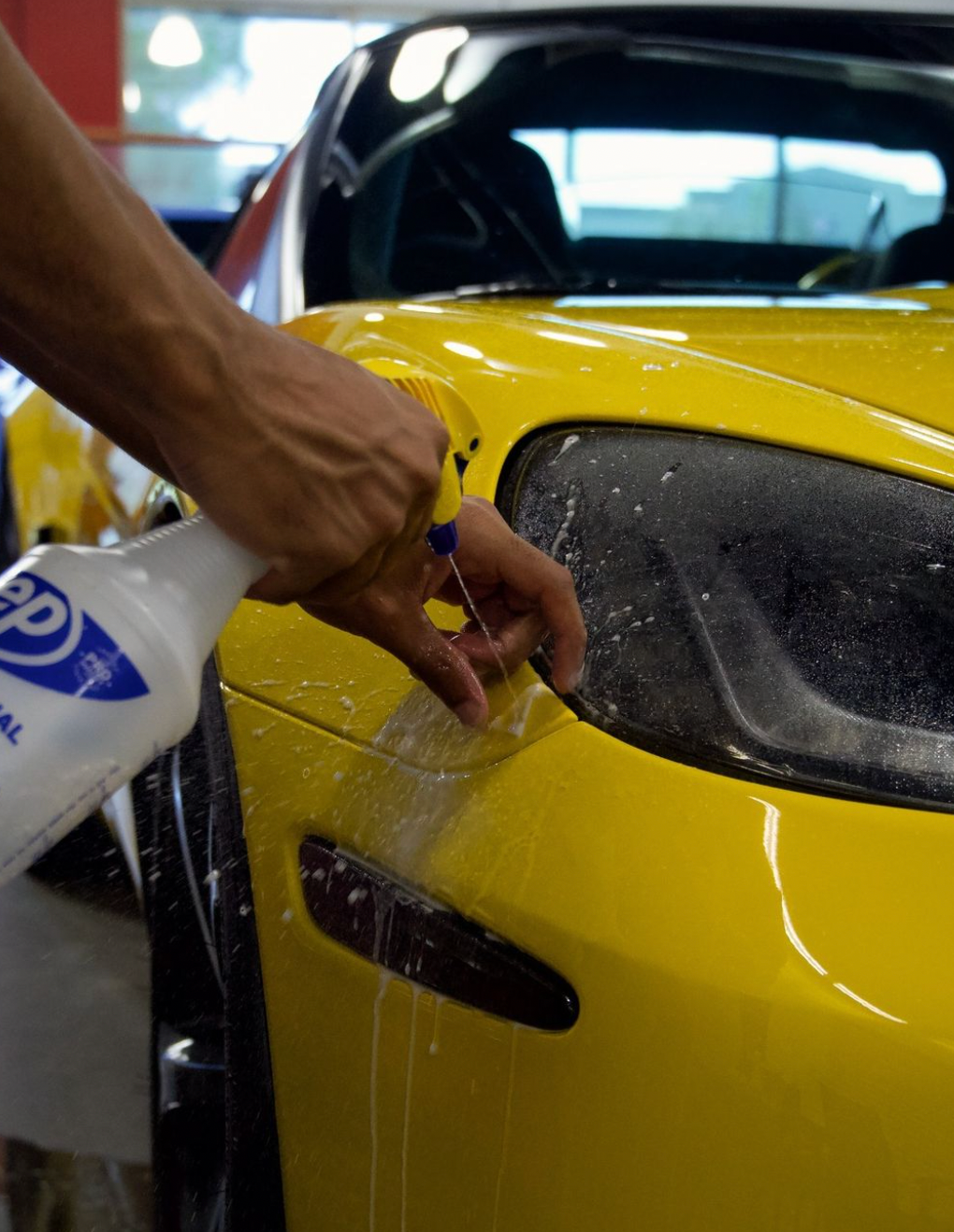 professional paint protection film installation on a yellow vehicle