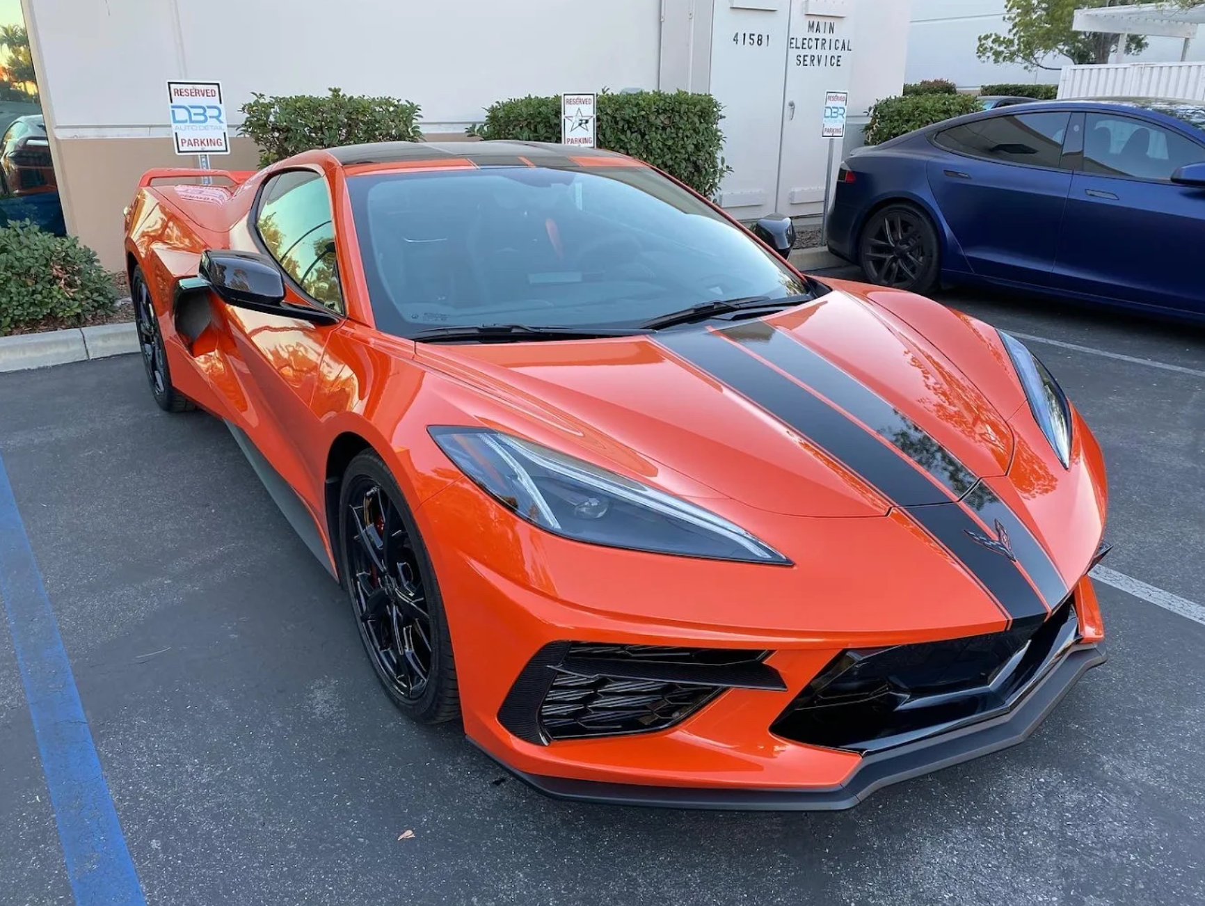 A red sports car is parked in a parking lot